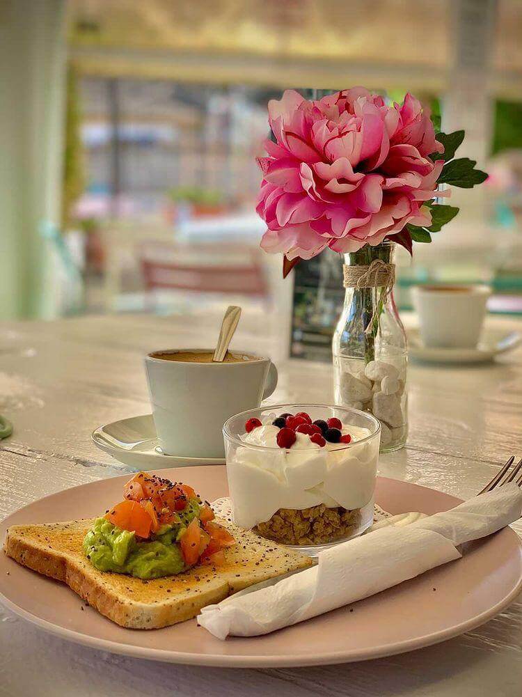 Desayuno con tostada de aguacate, yogur con frutas y café en Black & White Cafetería, El Puerto de Santa María